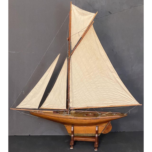 A handsome large English pond yacht from the Edwardian era, handcrafted from wood and brass and featuring vintage cloth...