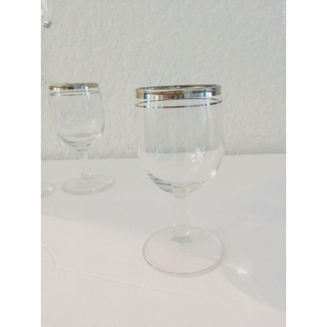 Lovely set of four mid-century stemmed clear wine glasses featuring double silver rims. Each glass holds 5 ounces.