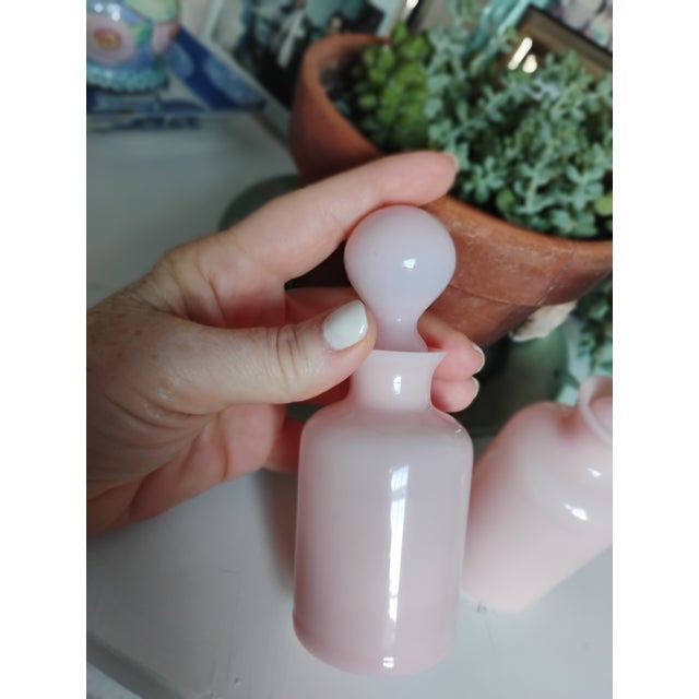 Charming mid-century rose opaline glass perfume bottle with a rounded stopper and soft, milky pink tone. The glass has a...