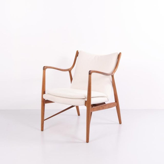 Lounge chair designed by finn juhl in 1952. The chair is crafted in walnut and upholstered in light fabric. The design has...
