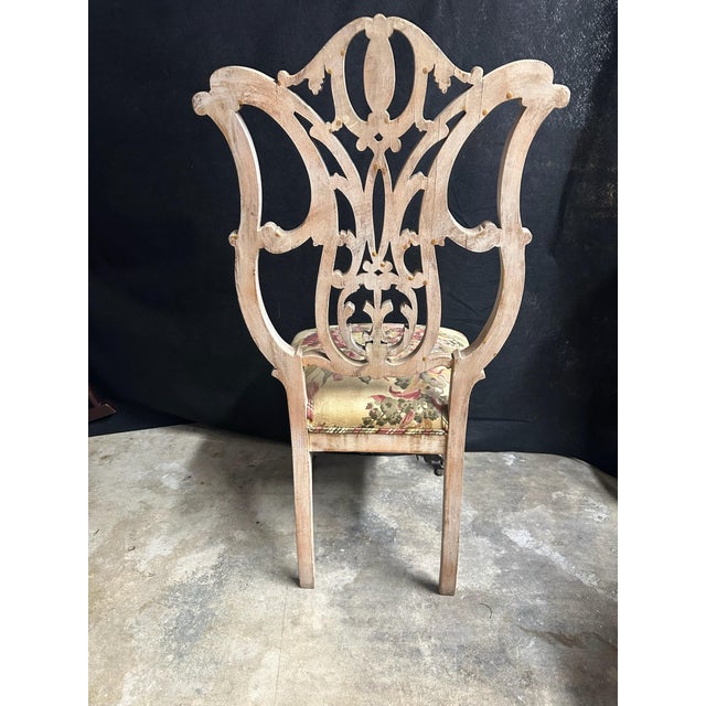 An ornate Rococo Revival–style side chair featuring an elaborate pierced wooden back with scrolling ornament, a central...