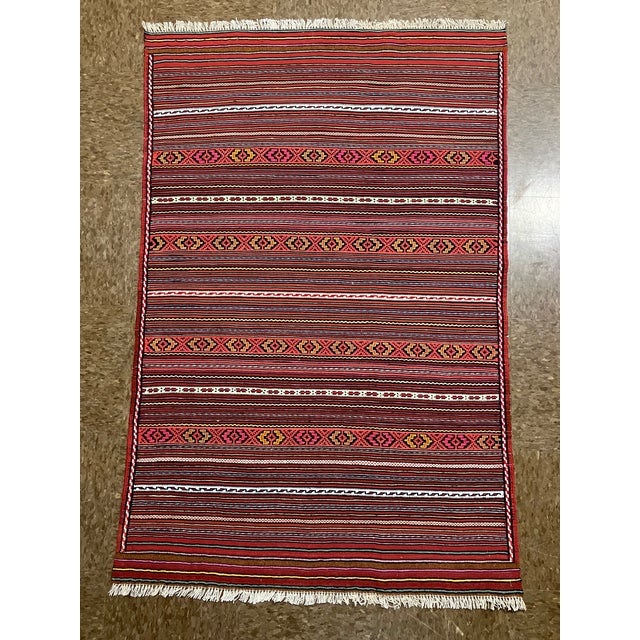 Handwoven Afghan Meymana kilim flatweave rug featuring a striped field with alternating horizontal bands of fine geometric...