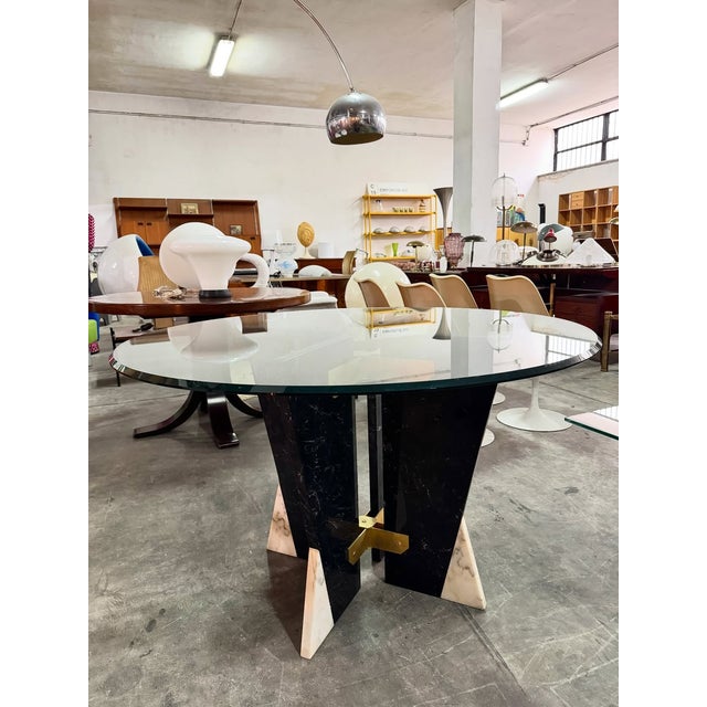 Dining table by Cattelan Italia, featuring a large round glass top that enhances the sculptural base underneath, from the...