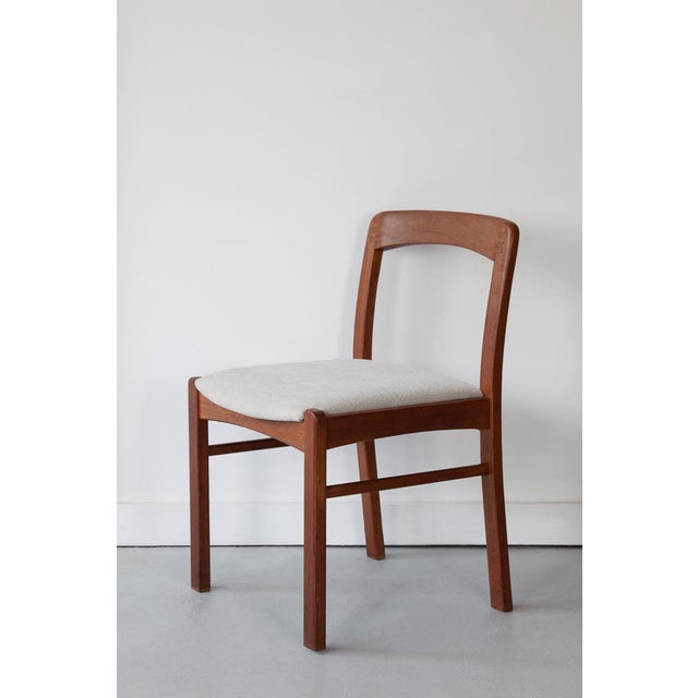 A set of six solid teak dining chairs showcasing beautiful joinery and a simple, elegent profile. Newly upholstered in a...