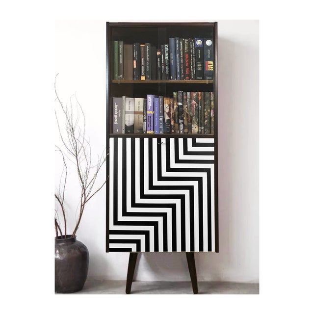 A tall display cabinet with a bar on slanted turned legs. Poland, 1970s in the upper part a display case with sliding...