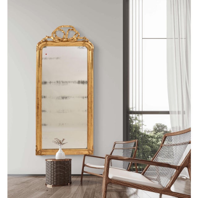 The elegant antique gilt mirror with crest presented here dates to the mid-19th century and is adorned at the top with a...