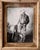 The artwork depicts a solitary figure in a cowboy hat, standing thoughtfully beside a rustic stable setting. Rendered in...