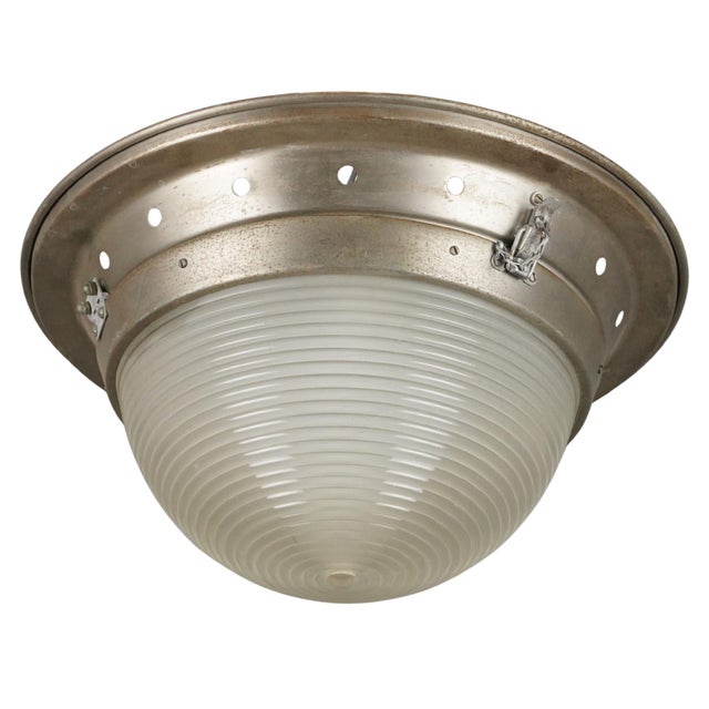 Industrial style flush mount ceiling light featuring a ribbed glass dome shade and a brushed steel base with visible...