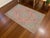 This is a beautiful vintage hand knotted distressed finish rug from Turkey. It has primary colors on petite orchid field....