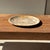 A small, round tray, dish, or plate made of petrified wood. Petrified wood is a fossilized wood (from the same family as...