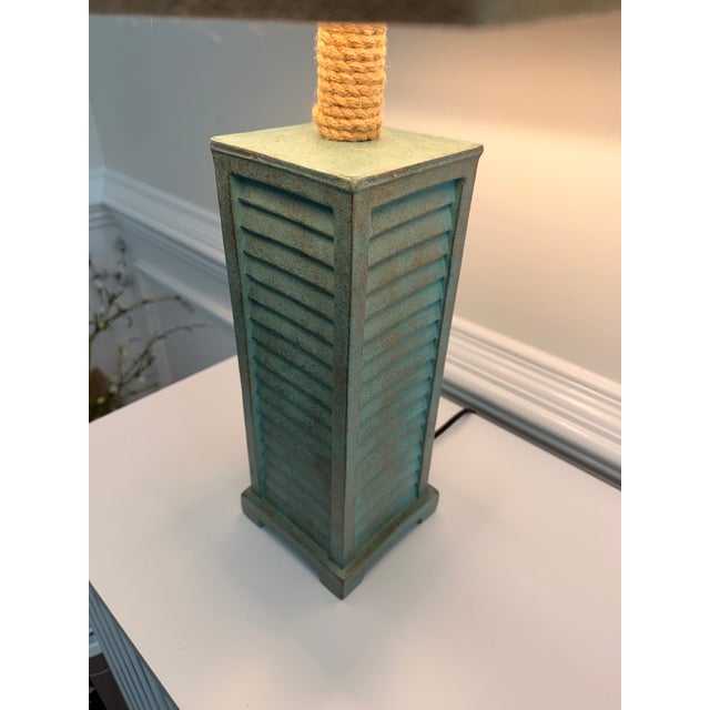 A stylish pair of coastal transitional table lamps featuring textured verdigris/gold finished column bases with...