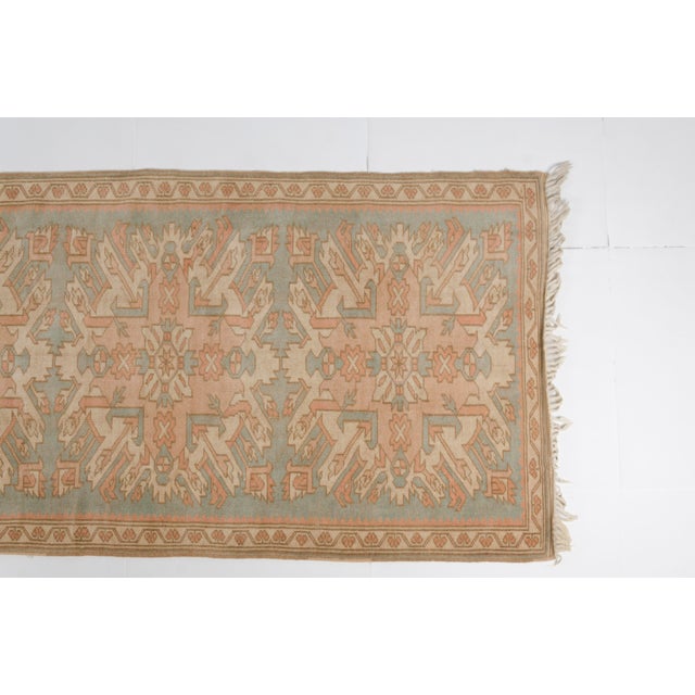 This is a vintage Turkish Oushak rug from the Mid 20th Century. The piece was hand-knotted.