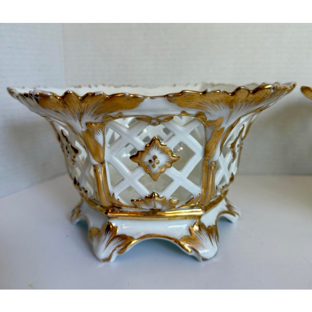 This elegant pair of porcelain jardinieres or cachepots dates to the late 19th to early 20th century and is executed in...