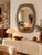 Vintage oval mirror with soft, organic lines, highlighted by a wide smoked glass frame. Its refined aesthetic evokes 1970s...