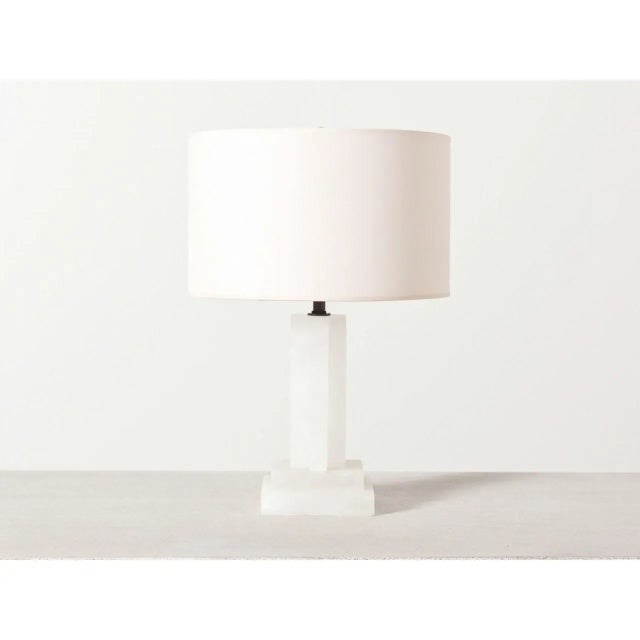 Alabaster table lamp with sculptural geometric base and round paper shade. Holds two medium base light bulbs. Lamp can be...