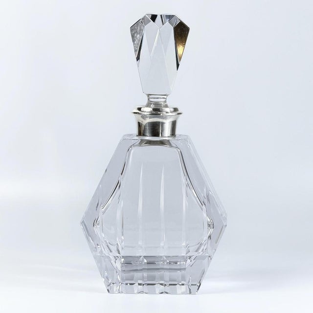 A striking mid-century cut crystal decanter of highly architectural form, likely French in origin, distinguished by its...