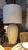 A stately white ceramic table lamp base with Art Deco fan and ginkgo leaf relief in arched panels, topped with a large...