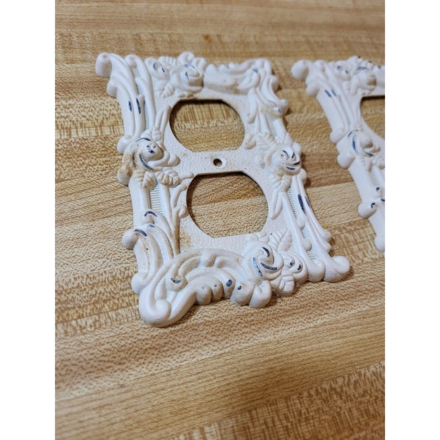 Mid-century design on these cast iron outlet covers. They appear to be salvaged and painted white.