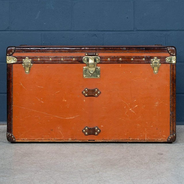 A striking and rare orange vuittonite courier trunk by louis vuitton, dating to circa 1900. This example is covered in the...