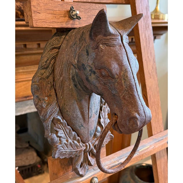 A horse stands at the front of a grand house. Someone needs to tie the reins to something. This is that something.A cast...