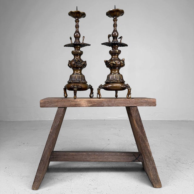 A decorative set of Japanese Buddhist altar candlesticks, butsudan shokudai, made from patinated bronze-coloured metal...