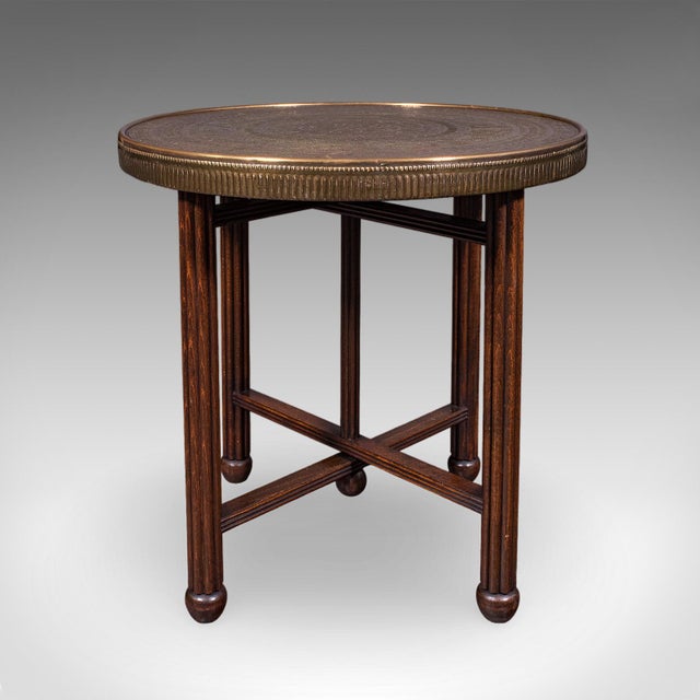 This is a vintage campaign tea table. A Middle Eastern, brass and beech Berber folding occasional table, dating to the Art...