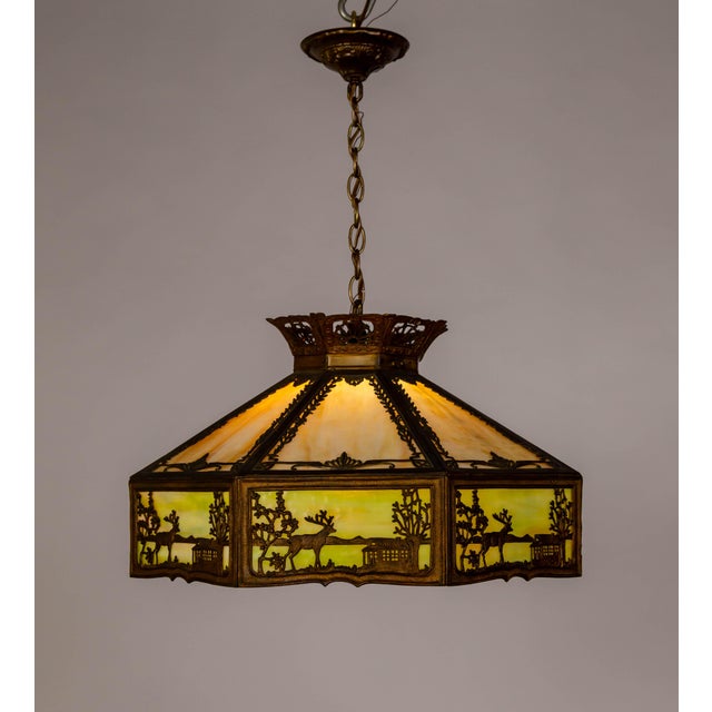 A detailed geometric umbrella-shaped slag glass pendant light fixture from the early 20th century. The slag glass is...