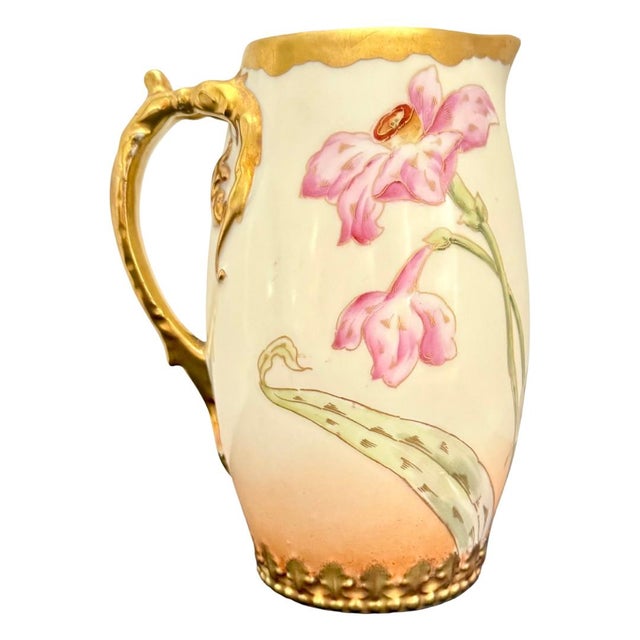 Hand-painted in France at the turn of the twentieth century, this Elite Works Limoges cider pitcher carries a spray of...