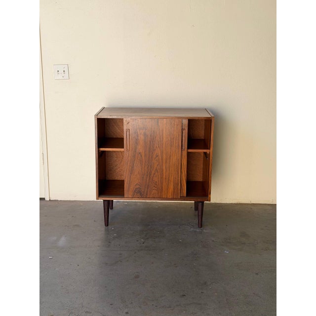 Danish rosewood cabinet is a classic example of Mid Century Modern Scandinavian design, combining clean lines with richly...