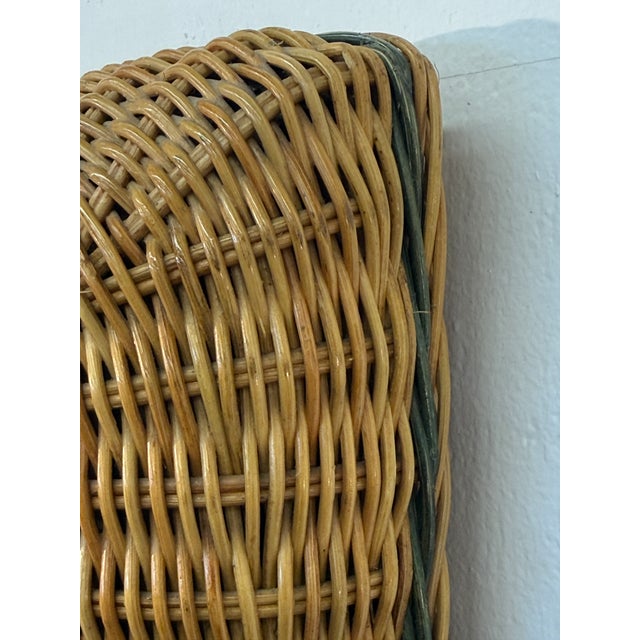 A beautifully crafted Italian wall mirror framed in thick hand-woven rattan, showcasing the warm, organic character that...