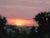 Sunset Over the Farm by Rob Rey | Oil Painting of a sunset over a rural landscape with a farmhouse. For Sale