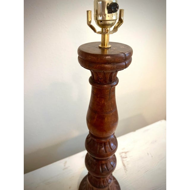 This Mid Century Modern lamp features unique, carved details with great texture as well as warm tones! Lightbulb not included