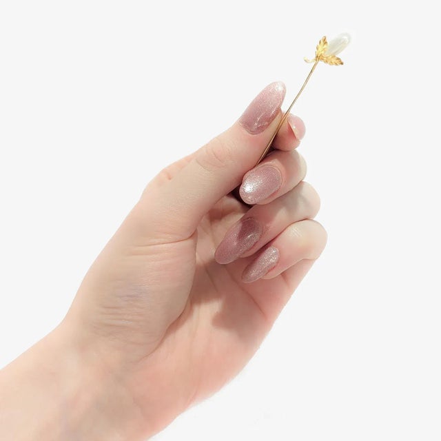A fine vintage, figural stickpin. In 14 karat yellow gold. In the form of a squash or possibly an eggplant. Set with a...