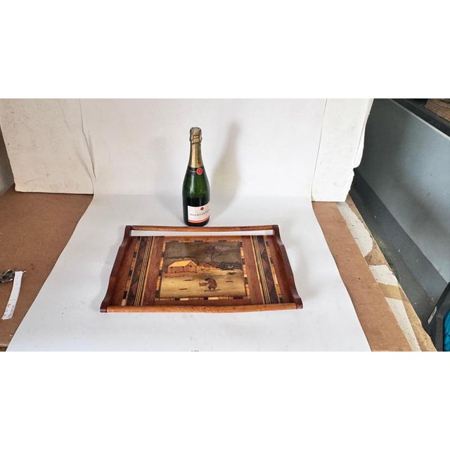 This traditional wooden tray was crafted in France in the 1950s using fine wood marquetry. The central scene depicts a...