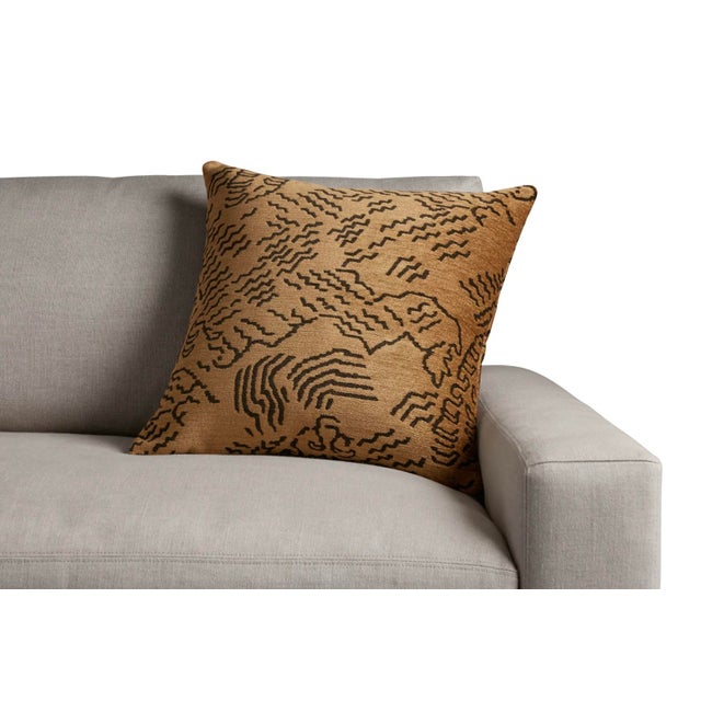 Arhaus Moura Pillow in Cognac. The pillow features a warm camel/tan base with black woven detailing. The cover is made...