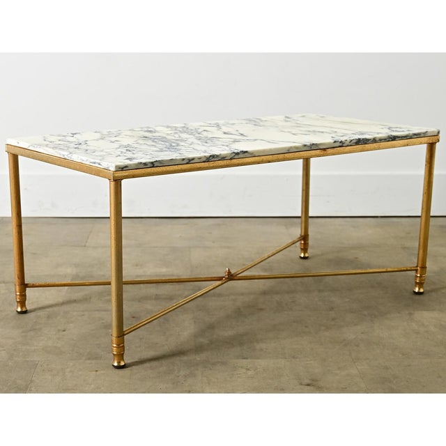 A vintage, midcentury French brass and marble coffee/cocktail table in the style of legendary firm Maison Jansen....