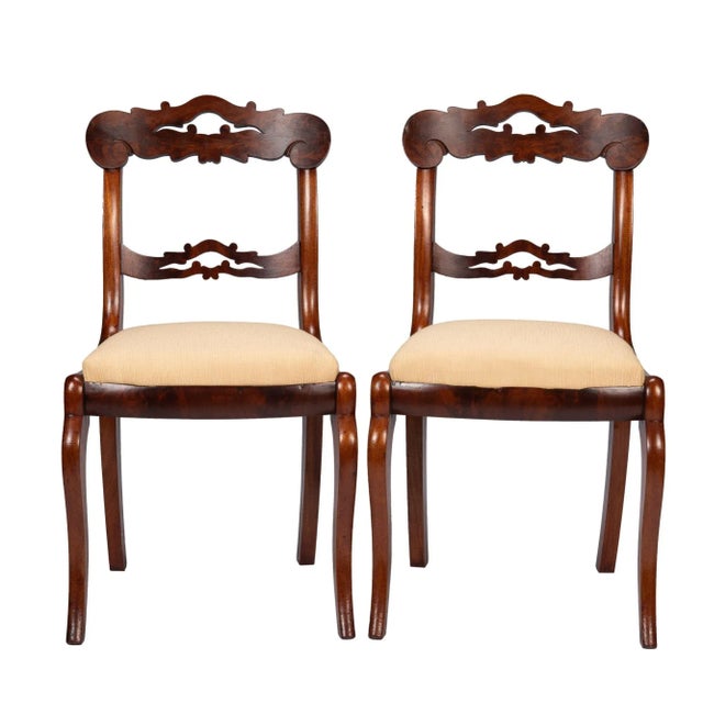 Pair of American mahogany and figured mahogany veneered late Classical upholstered slip seat side chairs. The chairs...
