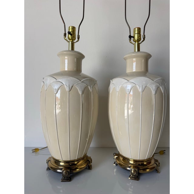 This striking pair of 1980s vintage table lamps features sculptural ceramic bodies in a soft beige glaze, accented by an...