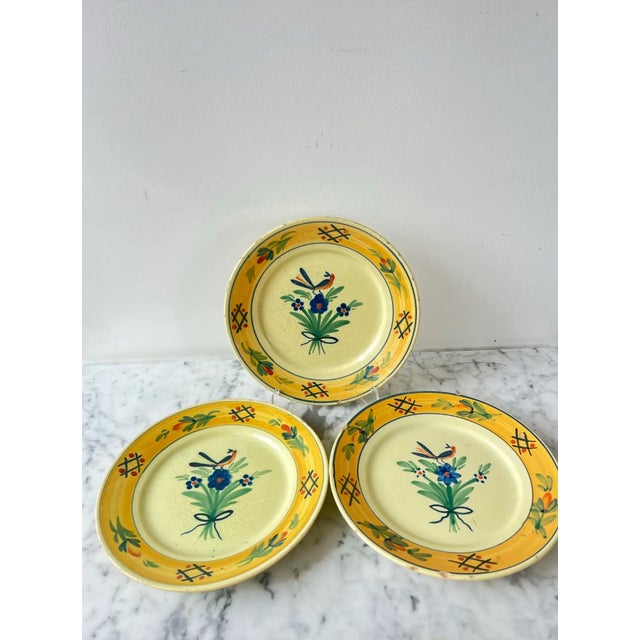 Quimper France hand-painted mustard and butter yellow plates with blue and orange bird, blue and green floral design and...