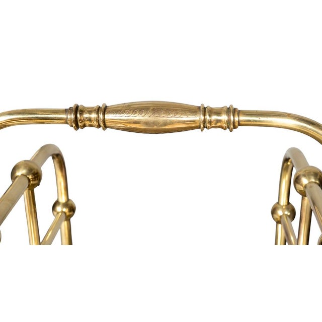 American brass wood holder. Stick and ball design with loop handle and bun feet.