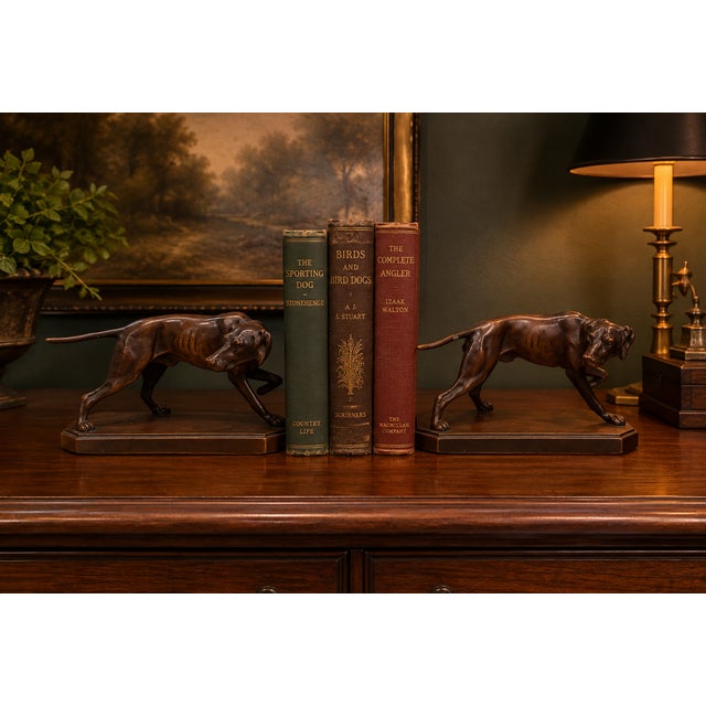 A handsome matched companion pair of vintage cast-metal hunting dog sculptures, each modeled in a stalking/pointing pose...