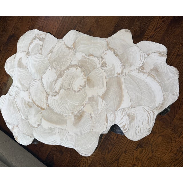 Table is made from a natural tree trunk mold with inlaid fossilized clam shell top. Base is stonecast. Clam shell is a...