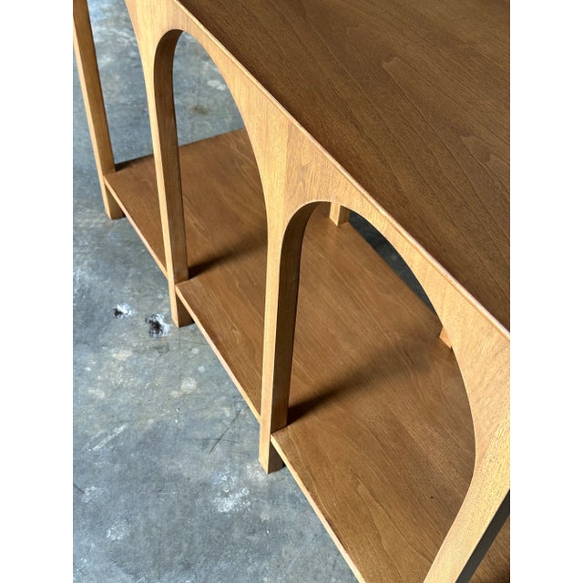 A stunning and rare console table designed by T.H. Robsjohn-Gibbings for Widdicomb, circa 1956. Features elegant arches on...