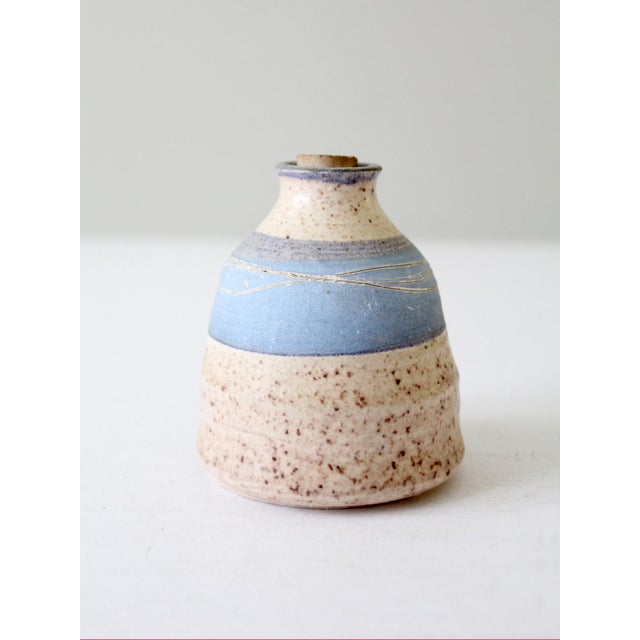 This is a vintage studio pottery jar. Signed by the artist, the handmade wheel turned vessel features a speckled tan glaze...