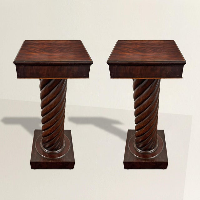 A stately pair of 19th-century American Empire pedestals, crafted from richly figured crotch mahogany with a deep,...
