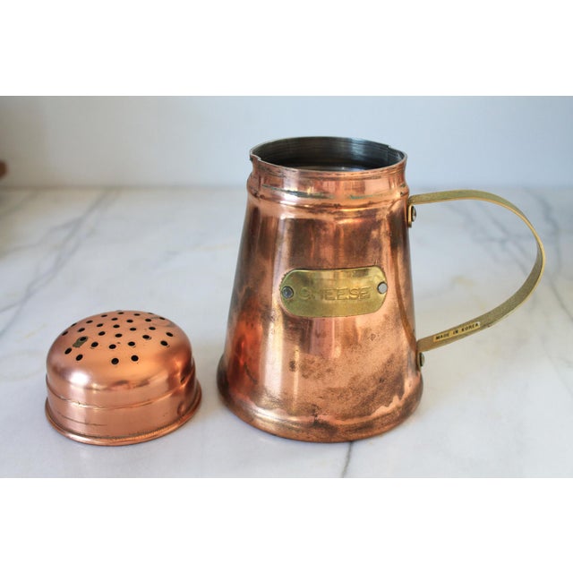 Vintage copper and brass cheese shaker. Made in Korea. Does show signs of age wear.