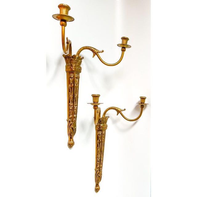 This elegant pair of vintage Neoclassical wall sconces features beautifully detailed torch-style backplates adorned with...