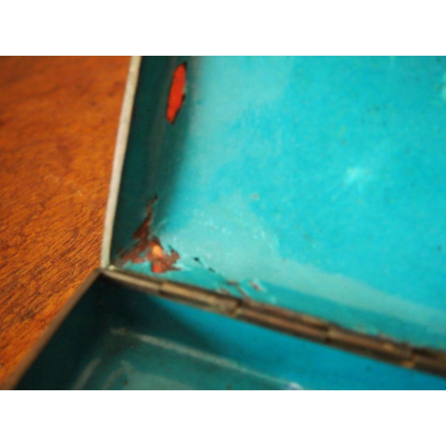 Chinese cloisonné box. Maroon red background with blue and pink flowers and green leaves. Raised on round feet. Underside...