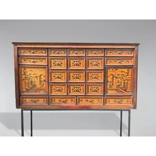 A North Italian provincial 18th-century richly decorated marquetry and inlay oak and walnut cabinet. It features a moulded...