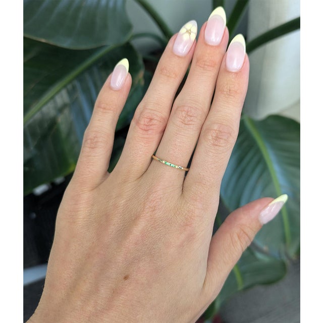 Elegant and timeless, this Tsavorite band ring is crafted in solid 14K yellow gold with a delicate minimalist design....